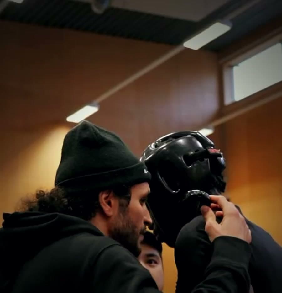 Tränaren coachar en kickboxare i ringhörnan på en tävling, från klubbens Instagram